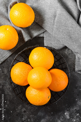 Obraz na płótnie Black metal basket with oranges on a black table w salonie