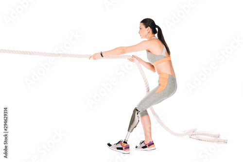 side view of disabled sportswoman training with rope isolated on white