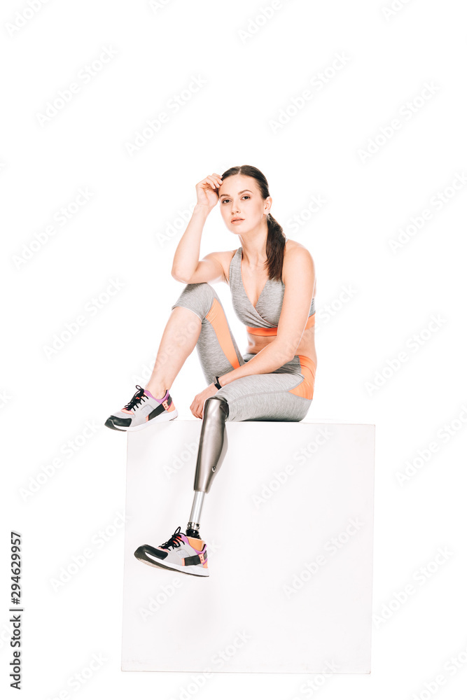 disabled sportswoman with prosthetic leg sitting isolated on white disabled sportswoman with prosthetic leg sitting isolated on white
