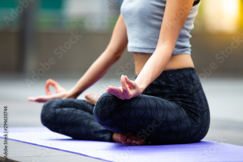 Close up hand of young Caucasian woman wearing sportswear practicing yoga in the city