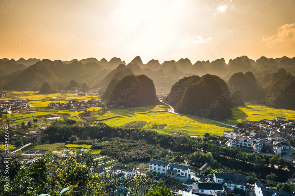 Obraz premium Rapeseed flower field and villages at Wanfenglin National Geological Park (Forest of Ten Thousands Peaks), China