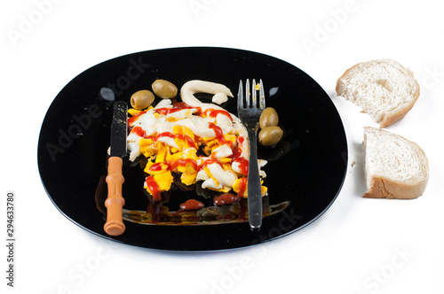 Fried egg on black plate isolated on white background.Eggs with kutchup,olives and bread