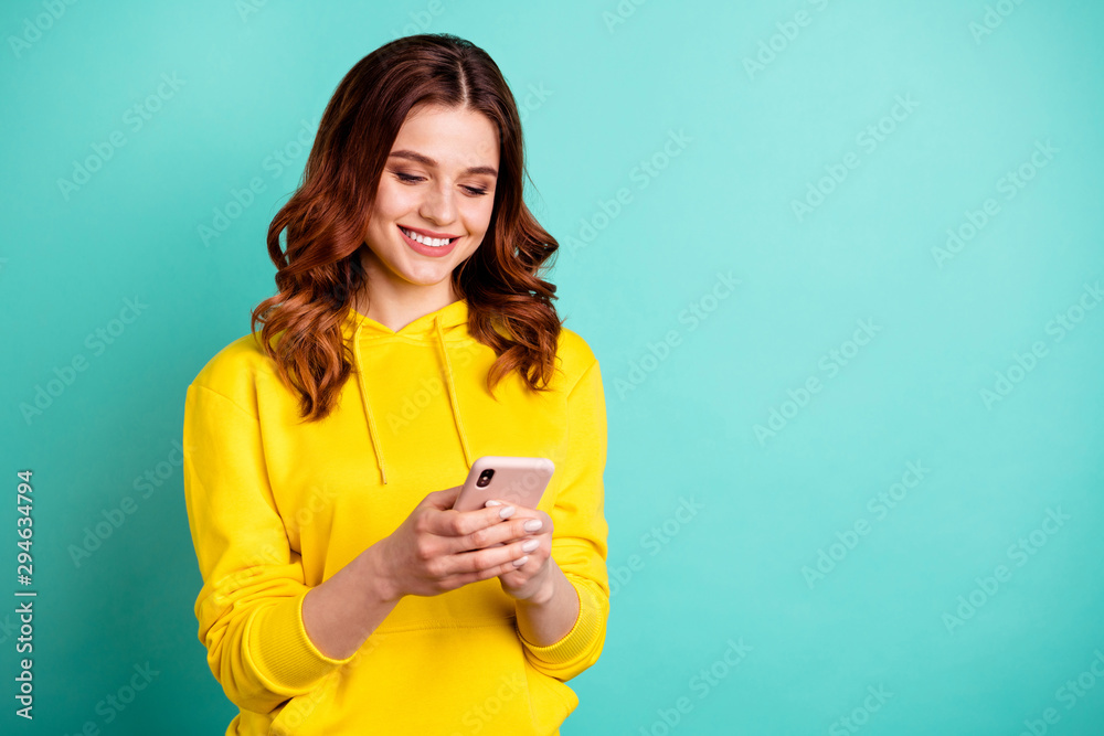 Photo of cute pretty charming nice girlfriend browsing through her telephone wearing yellow sweater isolated over turquoise vivid color background Photo of cute pretty charming nice girlfriend browsing through her telephone wearing yellow sweater isolated over turquoise vivid color background