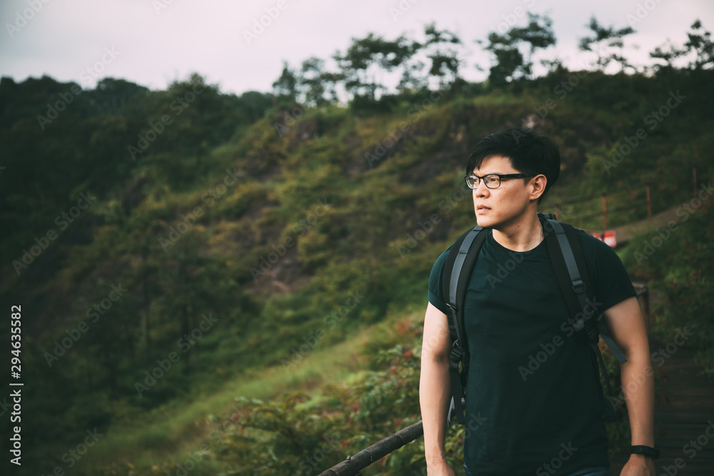 Man traveler with backpack hiking outdoor alone into the wild . .Travel Lifestyle wanderlust adventure concept Man traveler with backpack hiking outdoor alone into the wild . .Travel Lifestyle wanderlust adventure concept