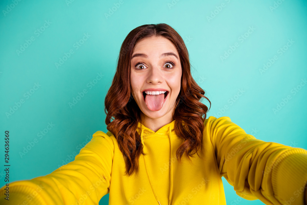 Photo of white trendy charming sweet cute nice youngster sticking tongue out showing her overjoyed facial expression wearing yellow sweater isolated over teal bright color background Photo of white trendy charming sweet cute nice youngster sticking tongue out showing her overjoyed facial expression wearing yellow sweater isolated over teal bright color background