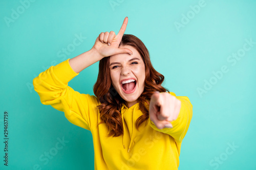 Photo of curly white wavy trendy cheerful charming sweet pretty cute schoolgirl teasing you showing you loser sign shouting isolated over teal vivid color background