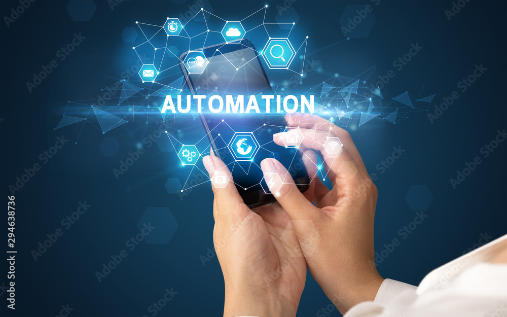 Obraz premium Ręka trzyma smartfon z napisem AUTOMATION, koncepcja nowoczesnych technologii