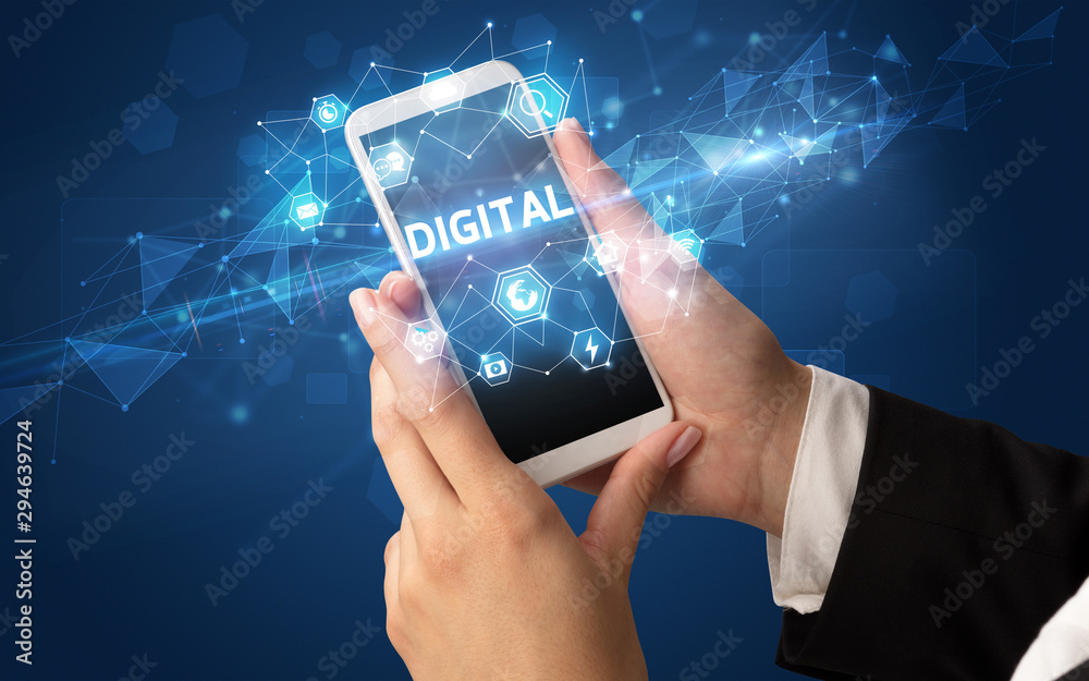 Female hand holding smartphone with DIGITAL inscription, modern technology concept Female hand holding smartphone with DIGITAL inscription, modern technology concept
