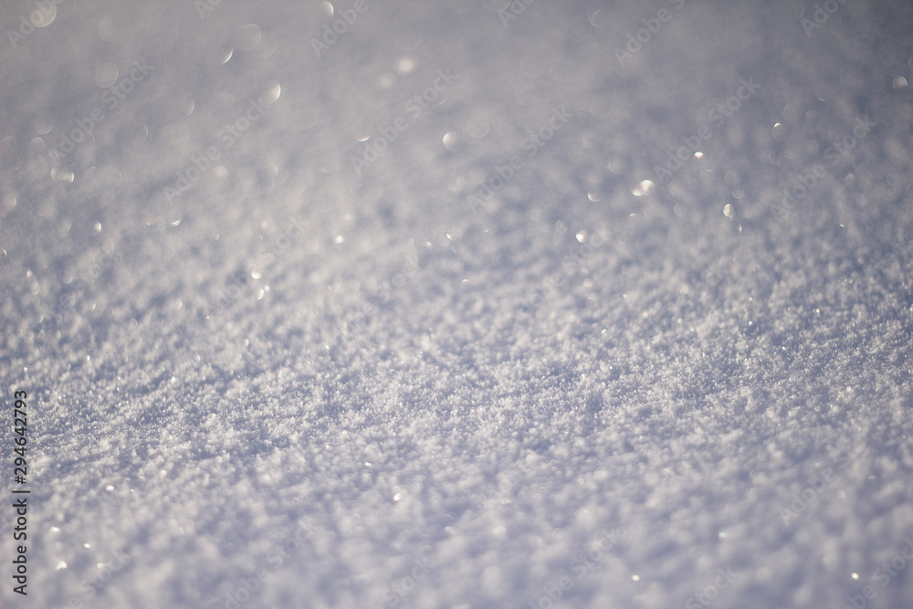 Snowy white background. The texture of the snow. Shiny snow with bokeh and blurred background close-up. White snow-covered field. Macro photo of snow. Snowy white background. The texture of the snow. Shiny snow with bokeh and blurred background close-up. White snow-covered field. Macro photo of snow.