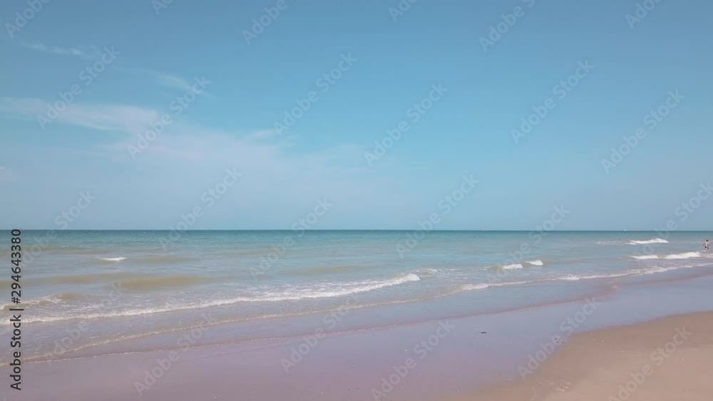 View of sand beach, sea and waves by a sunny day View of sand beach, sea and waves by a sunny day