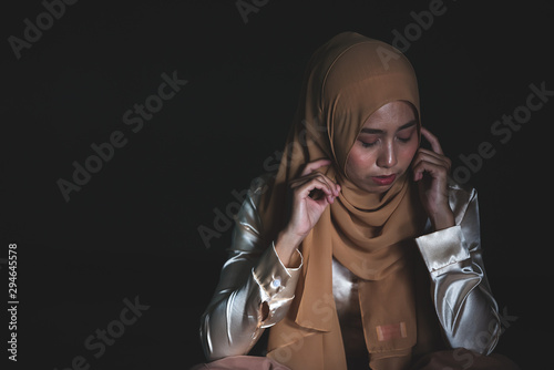 Young Muslim women sitting and feeling pain.. Lonely Muslim girl harly thinking how to solve life problem. photo