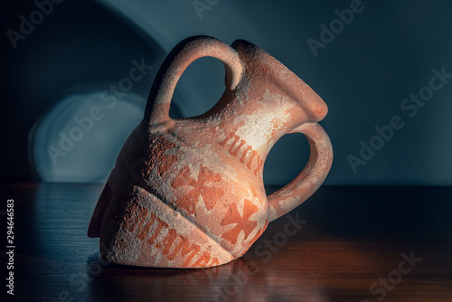 Broken old amphora on a wooden background