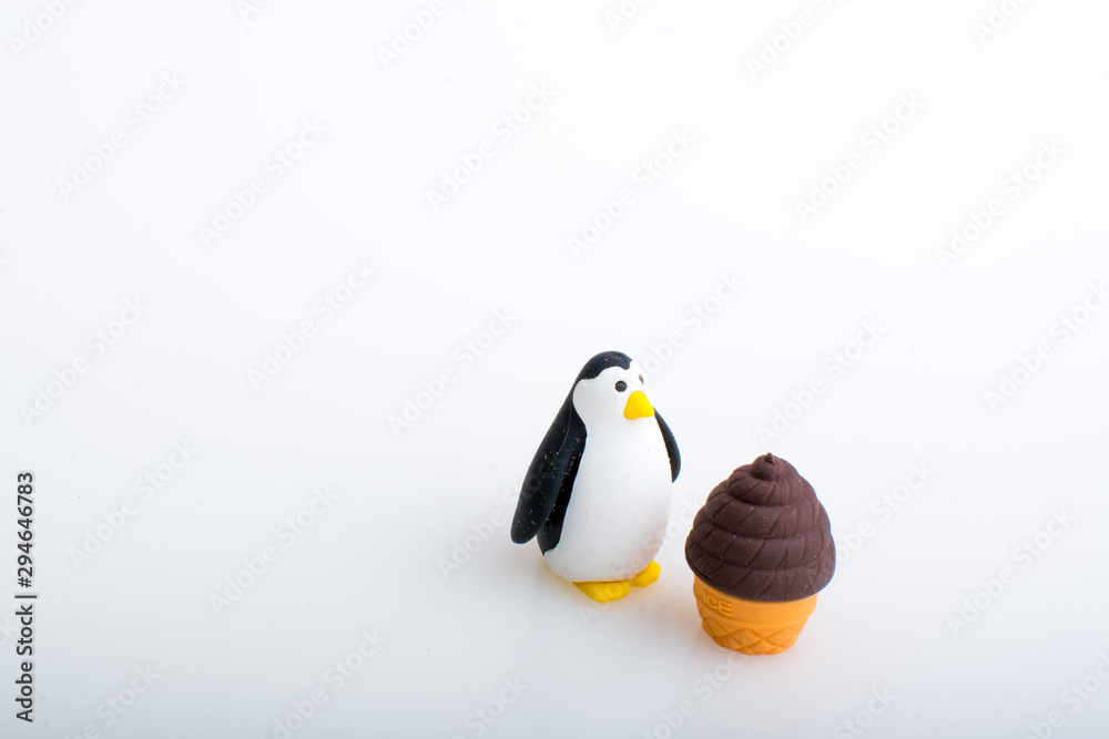 Fototapeta premium Penguin and ice cream rubber toys, cute animal shaped rubber doll isolated in white background.