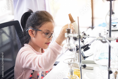 little asia kids girl in lab learning chemistry in school laboratory.