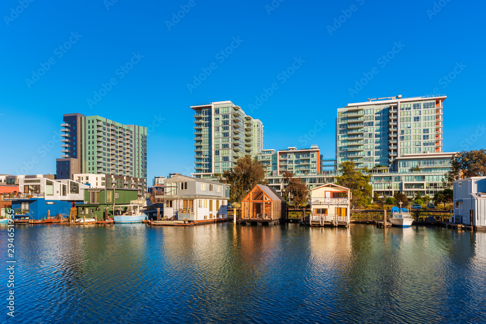Houseboats on Mission Creek Channel in Mission Bay district in San Francisco, California, USA. Newly developed apartment flats in the background.a