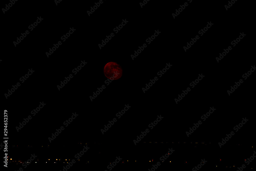 Cityscape at night. The rising of the full moon in the sunset red rays of the sun, began to wane. Cityscape at night. The rising of the full moon in the sunset red rays of the sun, began to wane.