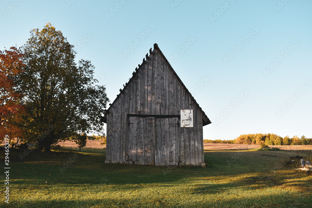 An old wooden barn on a field in autumn An old wooden barn on a field in autumn