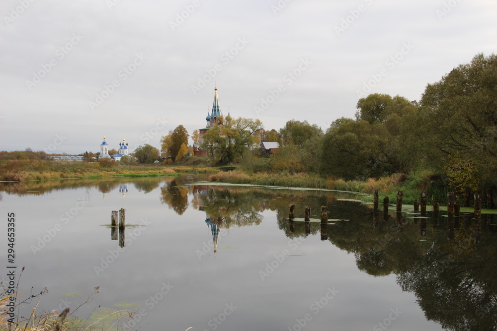Landscape of Dunilovo village with church and monastery on the river in cloudy fall day Landscape of Dunilovo village with church and monastery on the river in cloudy fall day
