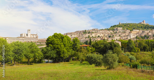 Panoramic view from countryside of the historic town of Assisi in beautiful sunny day with blue sky and clouds in summer  Umbria  Italy.