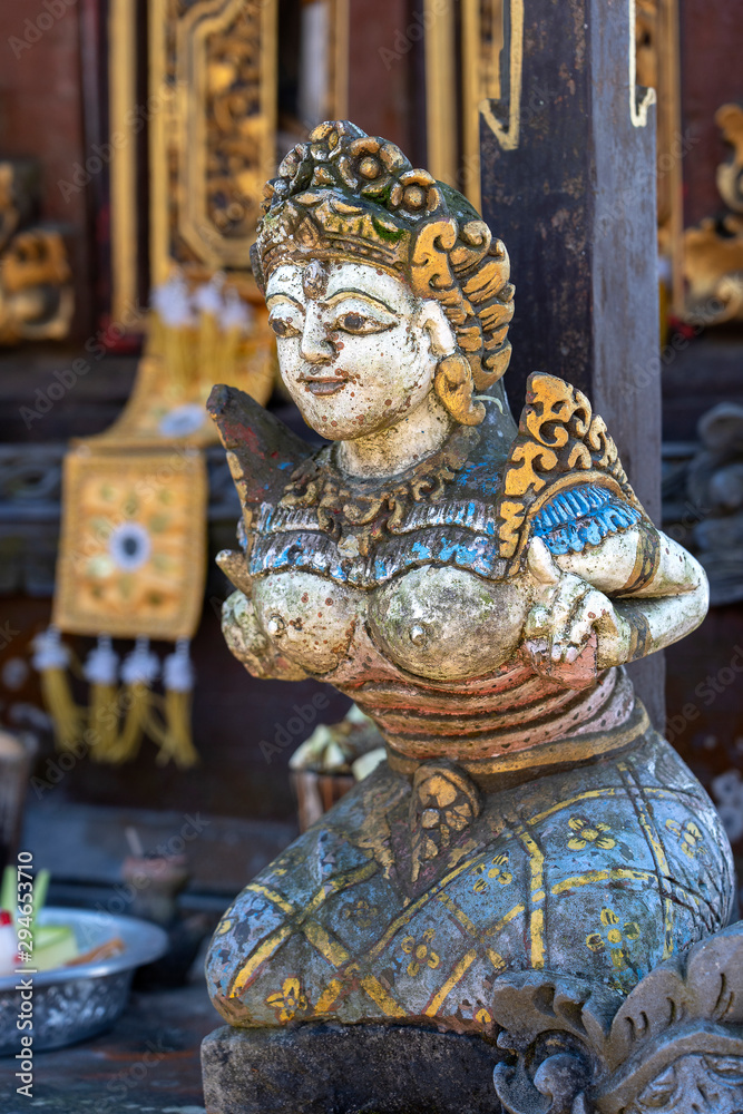 Traditional Balinese stone statuette of the deity in the street temple. Island Bali, Indonesia . Closeup