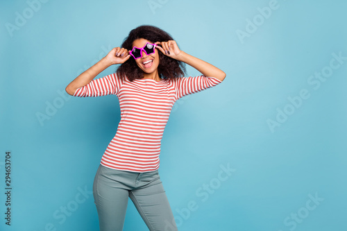 It's friday o'clock. Photo of funny dark skin lady ready start party wear star shaped sun specs casual clothes isolated pastel blue color background