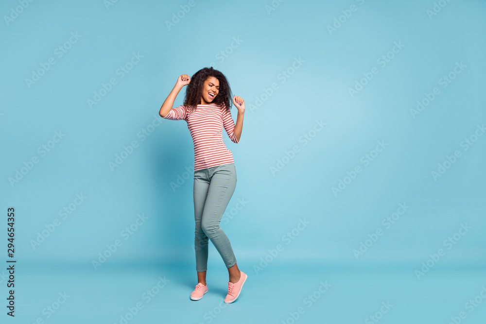 Full size photo of funny dark skin wavy lady enjoy amazing party mood funny chilling dancing wear casual clothes isolated pastel blue color background Full size photo of funny dark skin wavy lady enjoy amazing party mood funny chilling dancing wear casual clothes isolated pastel blue color background