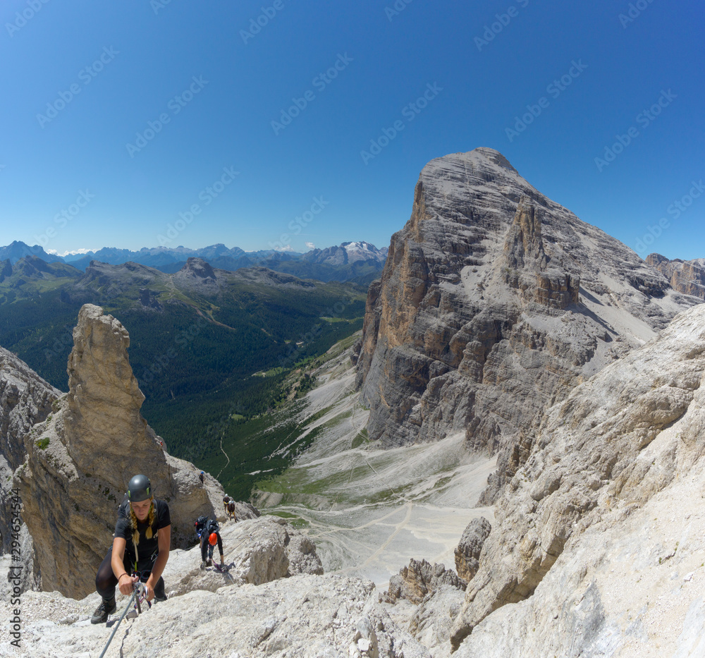 several mountain climbers on an exposed Via Ferrata in the Dolomites of Italy several mountain climbers on an exposed Via Ferrata in the Dolomites of Italy