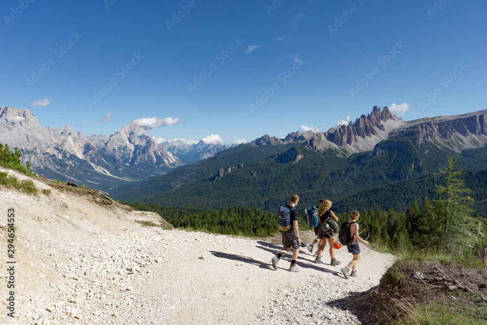 climbers walking down a road in a Dolomite mountain landscape after a hard climb