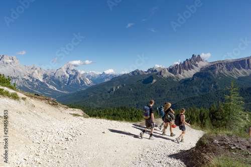 climbers walking down a road in a Dolomite mountain landscape after a hard climb