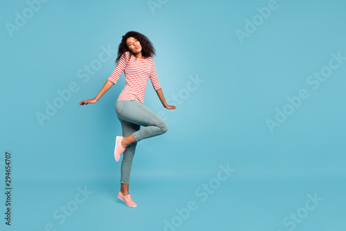 Full body photo of amazing dark skin lady walking street sunny day sending handsome stranger shy kisses wear casual clothes isolated pastel blue color background