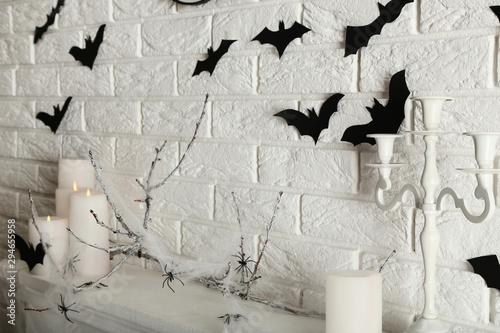 White candles with black papre bats and candlestick on brick wall background photo