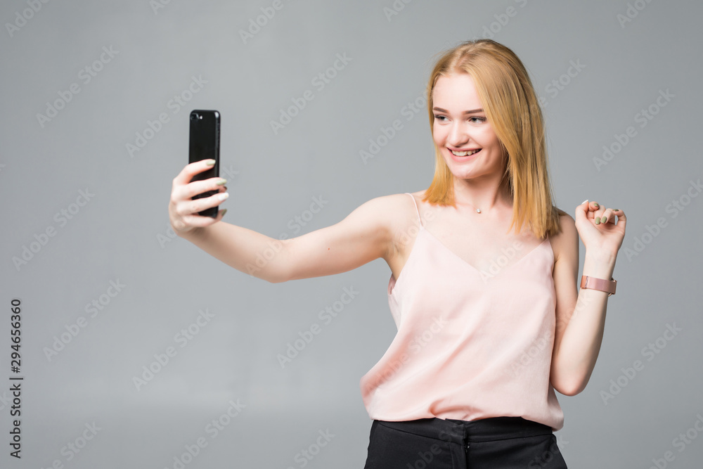 Pretty teen girl taking selfies with her smart phone isolated on white background Pretty teen girl taking selfies with her smart phone isolated on white background