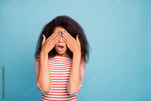 Photo of scared terrfied black woman covering her eyes after examination by oculist near empty space isolated over blue vivid color background © deagreez