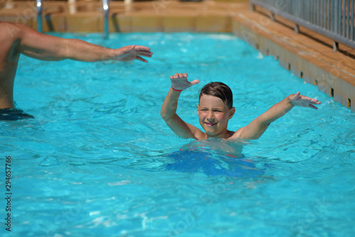 Cute European boy dancing aqua Zumba in hotel’s pool during his summer vacations. Healthy active childhood concept. © Artem