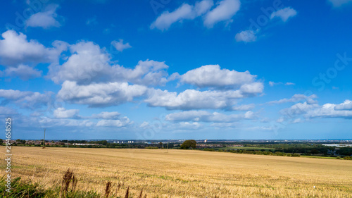Recently harvested field set against a beautiful blue sky with white clouds with the City of Sunderland in the distance.  Taken on a warm autumn day.