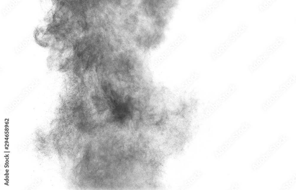 Black powder explosion against white background.Charcoal dust particles cloud in the air.