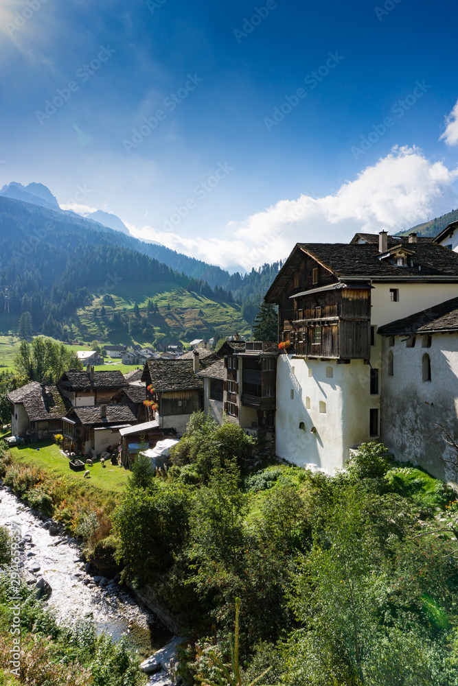 picturesque mountain village with white stone houses and stone roofs in the Swiss Alps