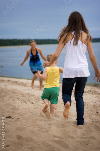 Mother and son running on the beach. Concept of family life and summer vacations
