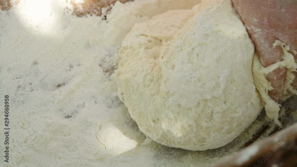 Housewife kneading dough in a wooden bowl Housewife kneading dough in a wooden bowl