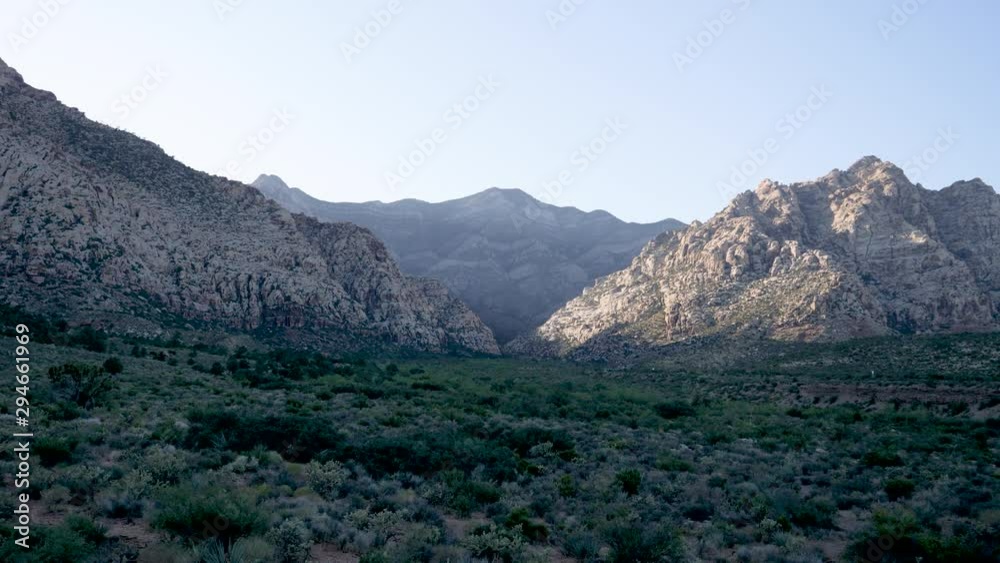 Drive Plate-Rugged Spring Mountains in the shade at sundown in the Red Rock Canyon National Conservation Area west of Las Vegas Nevada passing desert vegetation-Side view