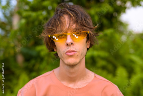 Young handsome rebellious man outdoors wearing glasses