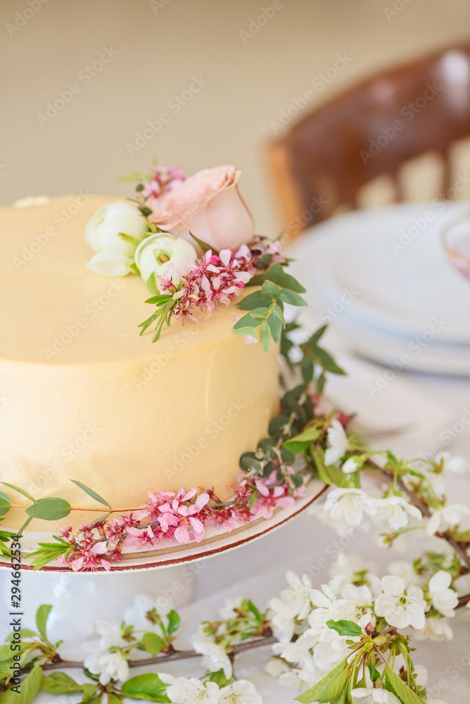 Wedding cake with flowers, boho style table setting. Holiday cake on table