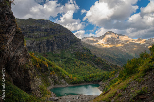 A green lake surrounded by mountains and autumn forest. Turye lake in Dombay.