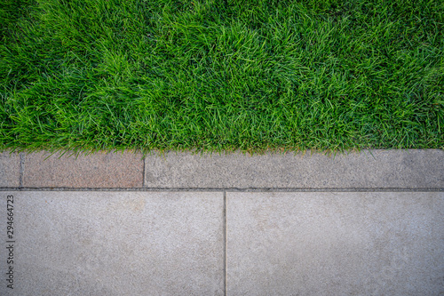 Obraz na płótnie Top view of green grass texture with cement sidewalk. w salonie