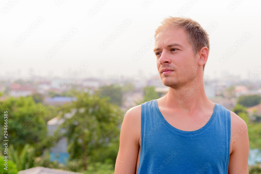 Young handsome man with blond hair relaxing outdoors Young handsome man with blond hair relaxing outdoors