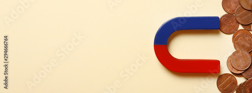 Foto Magnet attracting coins on beige background, flat lay