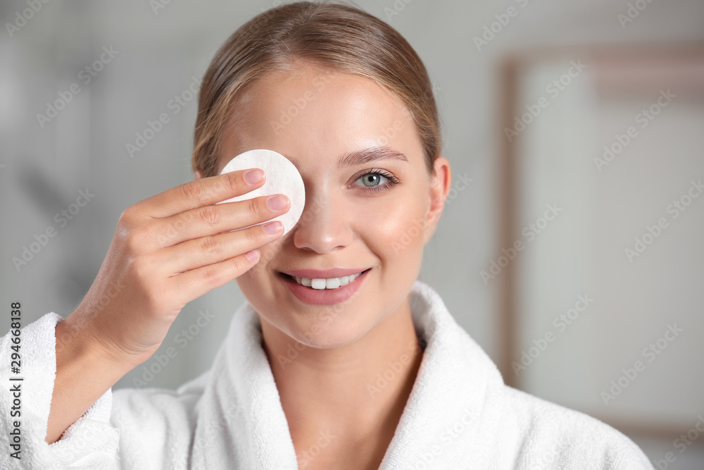 Beautiful young woman with cotton pad indoors Beautiful young woman with cotton pad indoors