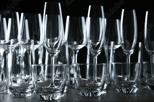 Set of empty glasses on table against black background