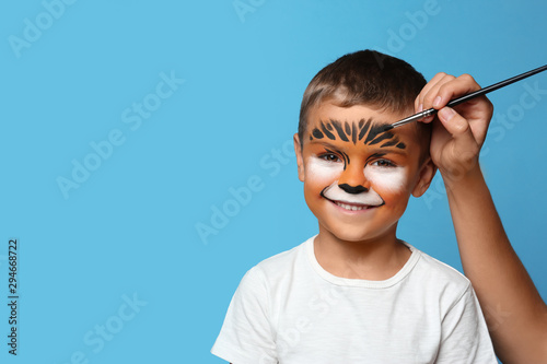 Obraz na płótnie Artist painting face of little boy on blue background