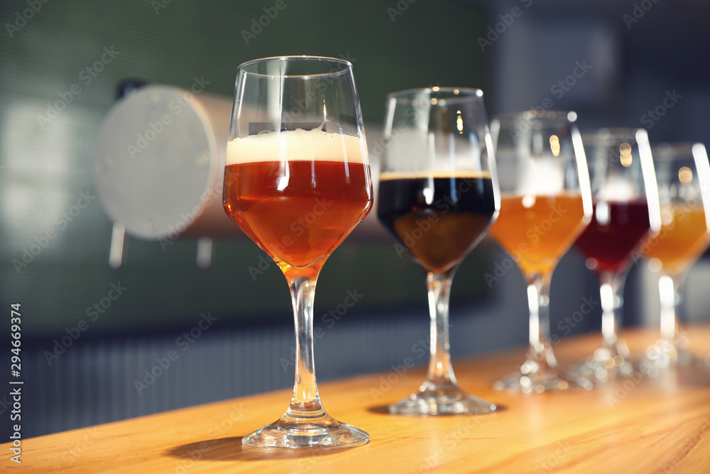Different sorts of beer on wooden bar counter Different sorts of beer on wooden bar counter